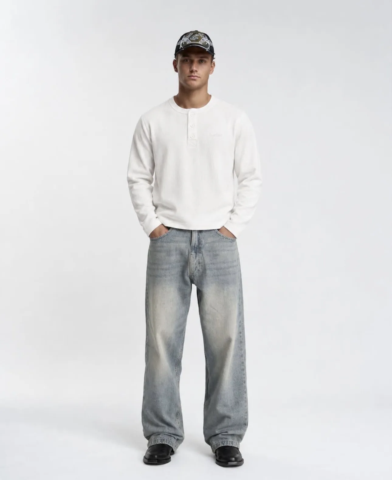 Male model wearing the white Matteo Henley, full-length front view