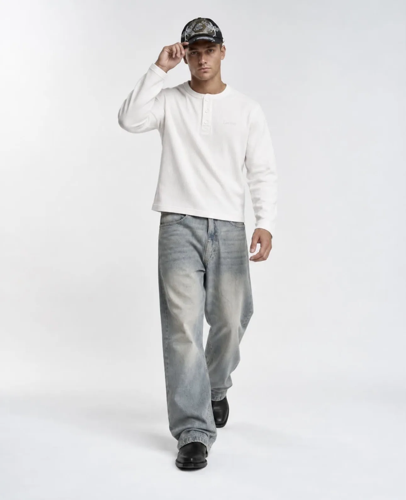 Male model wearing the white Matteo Henley, walking front view
