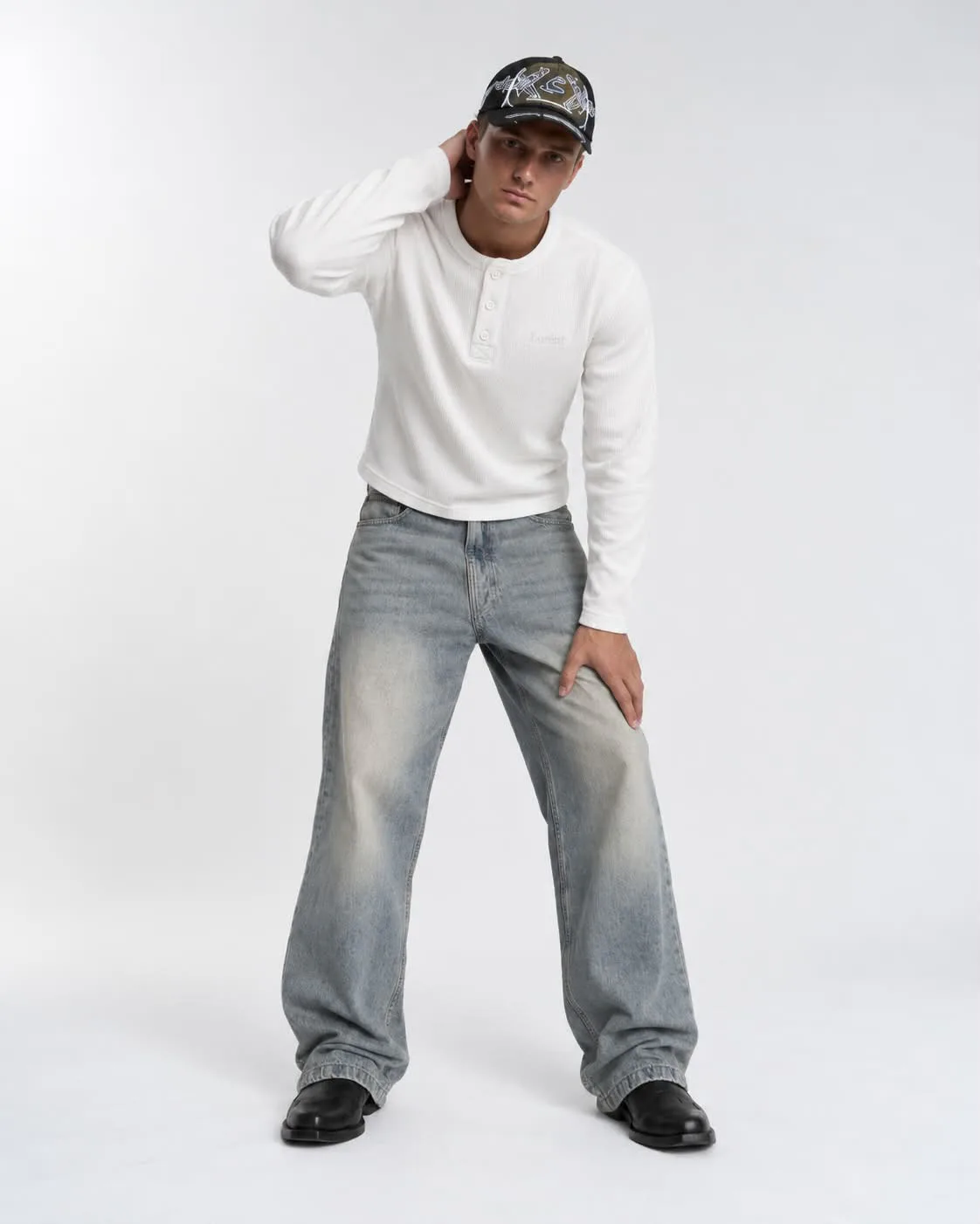 Male model wearing the white Matteo Henley, relaxed pose
