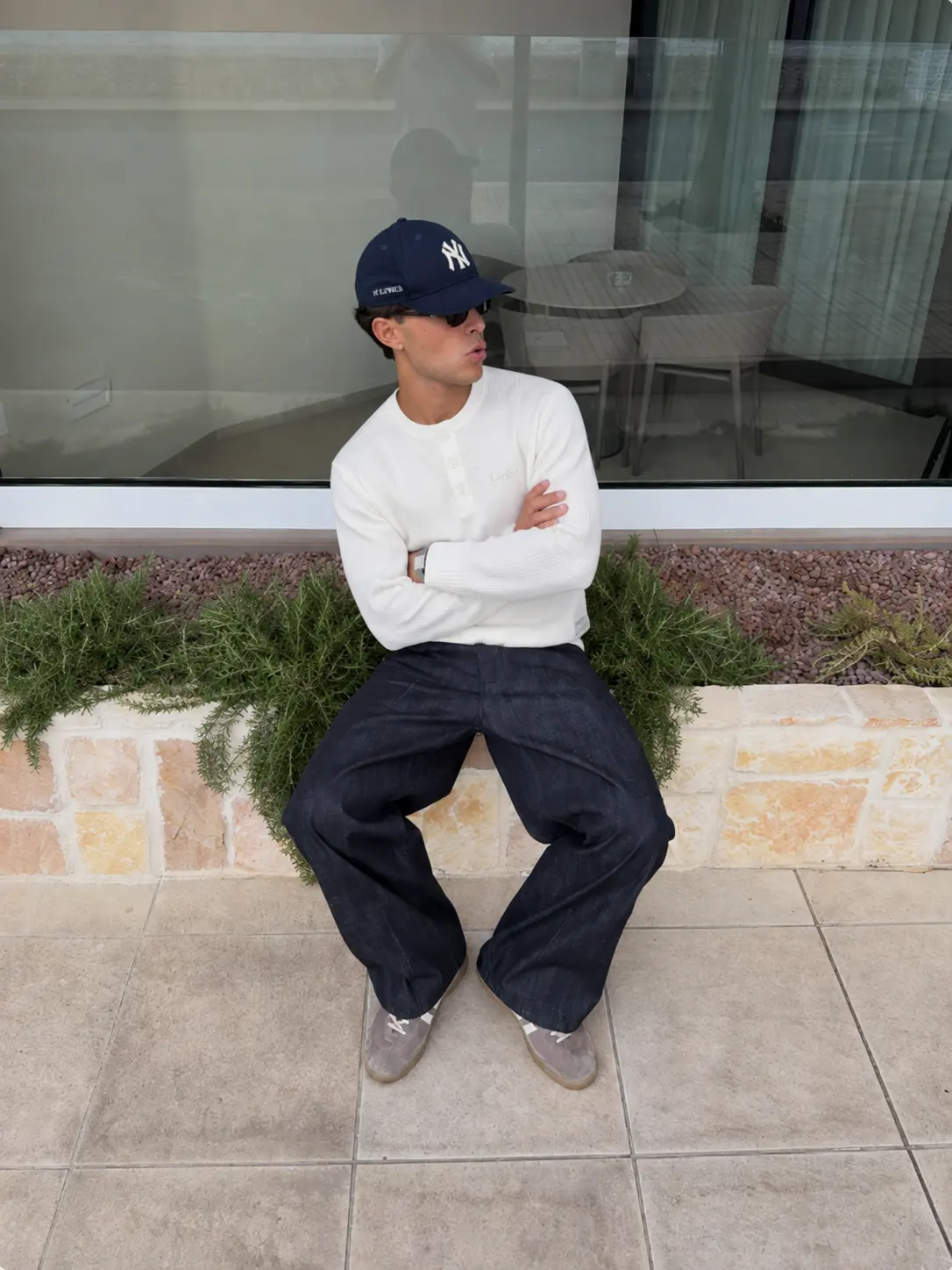Model wearing the white Matteo Henley seated outdoors